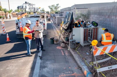 Road construction crew working on utility infrastructure with safety equipment