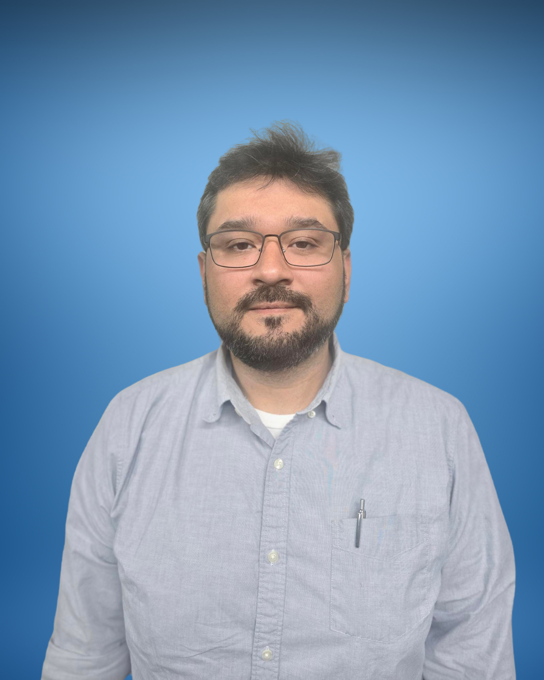 Professional wearing glasses in gray shirt against blue background