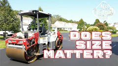 Road roller compacting asphalt on suburban street during pavement maintenance
