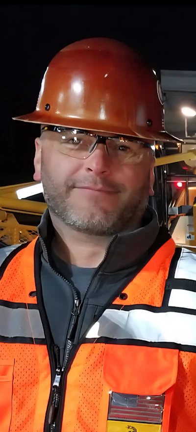 Construction worker in safety gear at industrial site at night