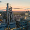 Industrial manufacturing facility at sunset with complex machinery and illuminated infrastructure