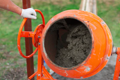 Orange concrete mixer with cement, ready for construction work
