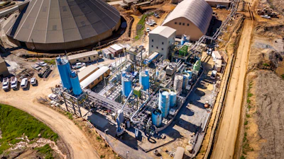 Industrial chemical processing plant with blue tanks and intricate piping infrastructure
