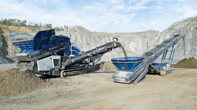 Mobile rock crushing equipment in quarry with industrial machinery on rocky terrain