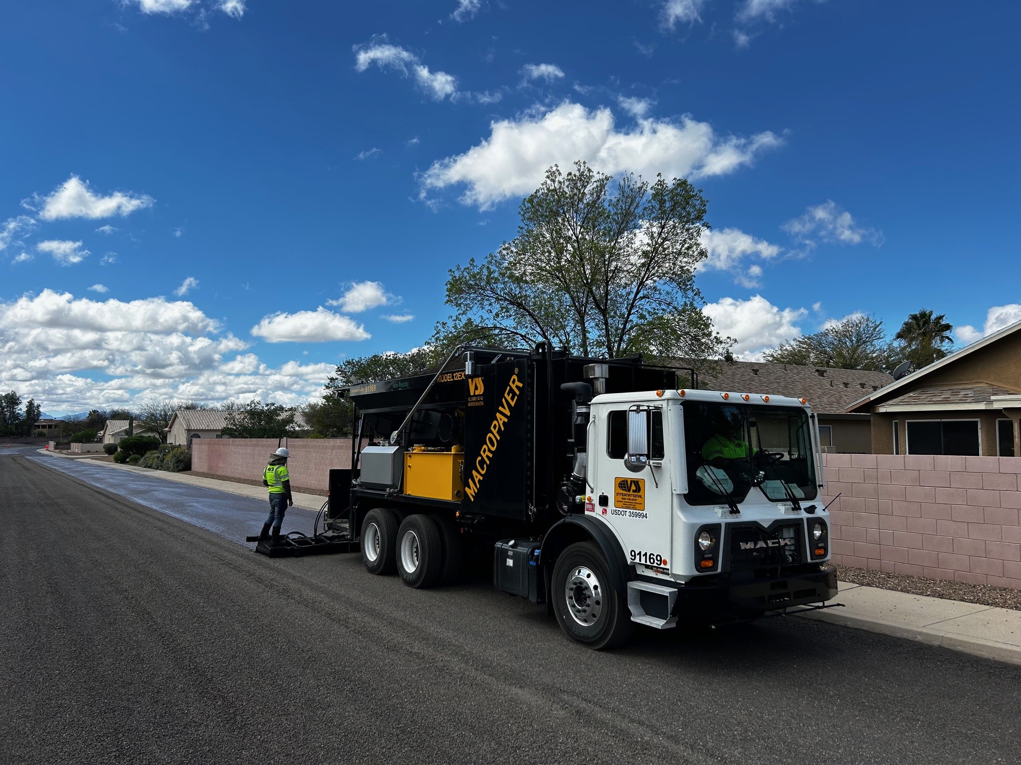 Road maintenance truck applying asphalt sealant on suburban street