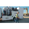 Industrial work truck with machinery and safety-vested worker at construction site