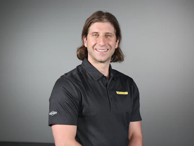 Smiling professional in black polo shirt with medium-length hair