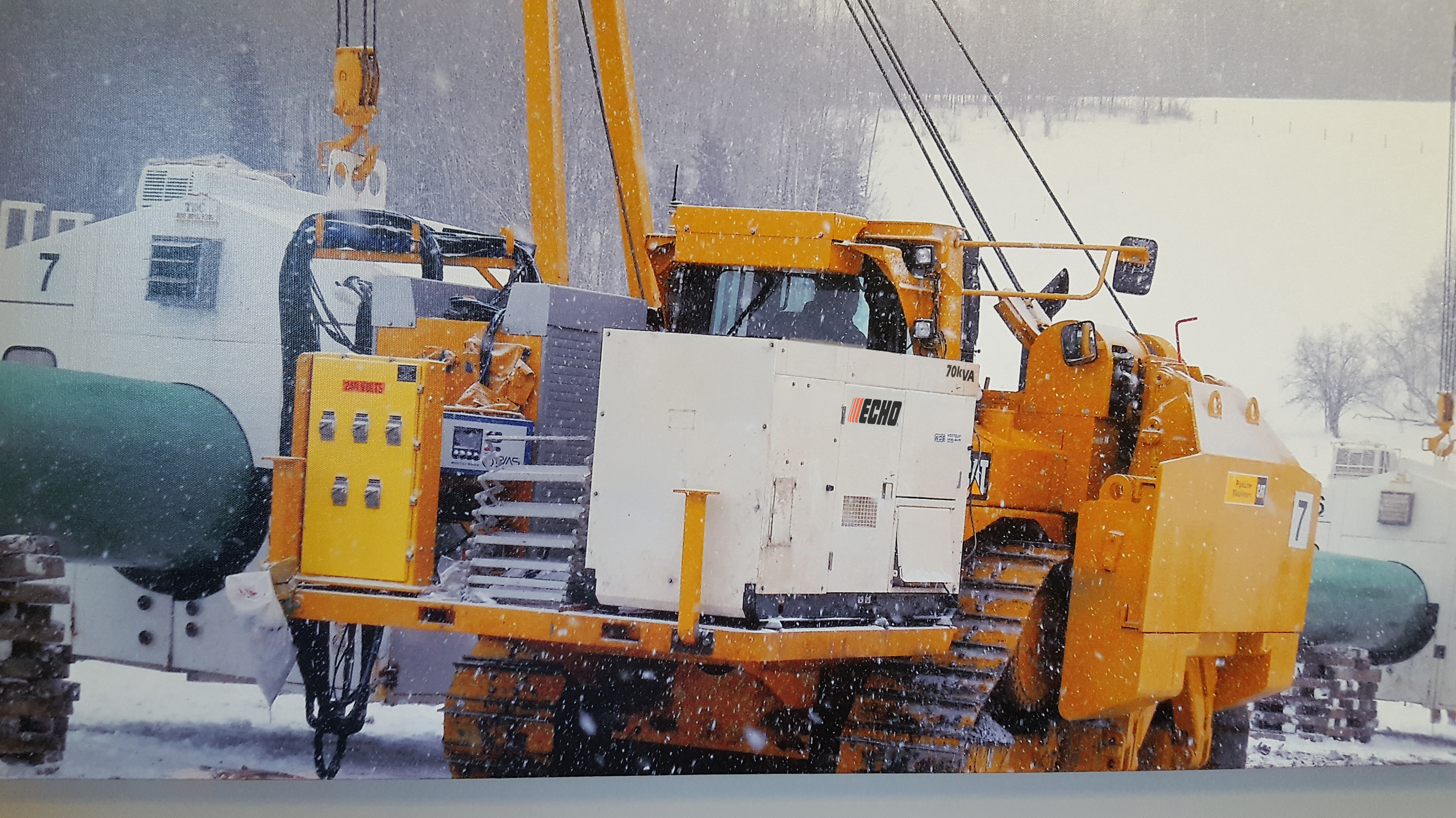 Heavy yellow tracked industrial vehicle in snowy construction site