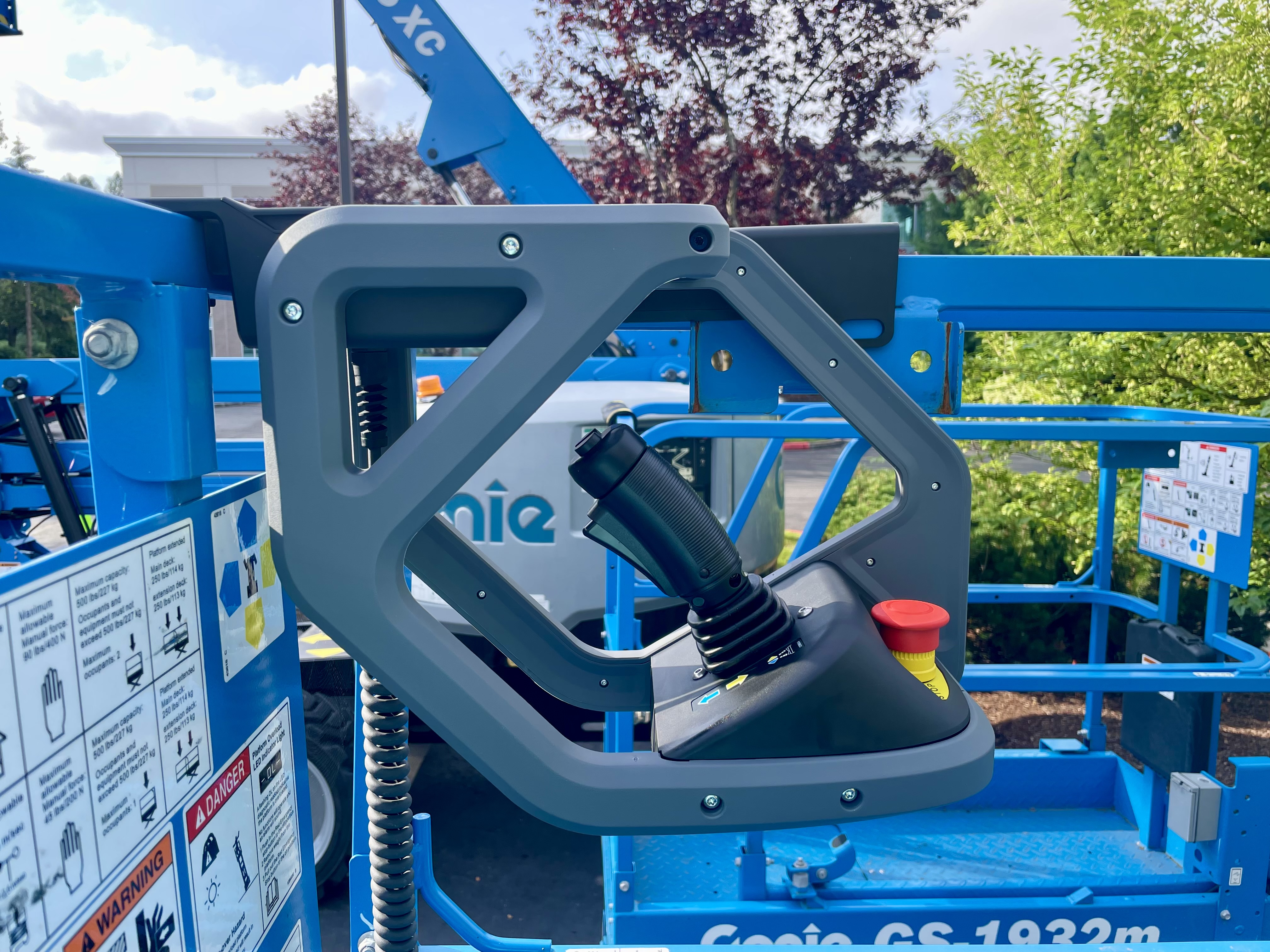 Close-up of grey control joystick mounted on blue Genie GS-1932m aerial lift platform equipment