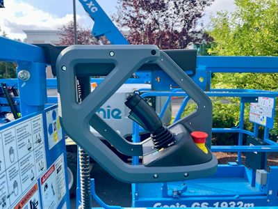 Close-up of grey control joystick mounted on blue Genie GS-1932m aerial lift platform equipment