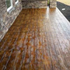 Wooden-textured stamped concrete patio with stone wall borders