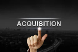 Hand pressing digital 'ACQUISITION' button on dark background