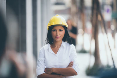 Construction professional in yellow safety helmet standing confidently outdoors