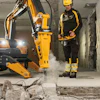 Yellow Brokk demolition robot breaking concrete in indoor construction site