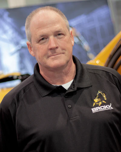 Middle-aged professional in black Brokk company polo shirt
