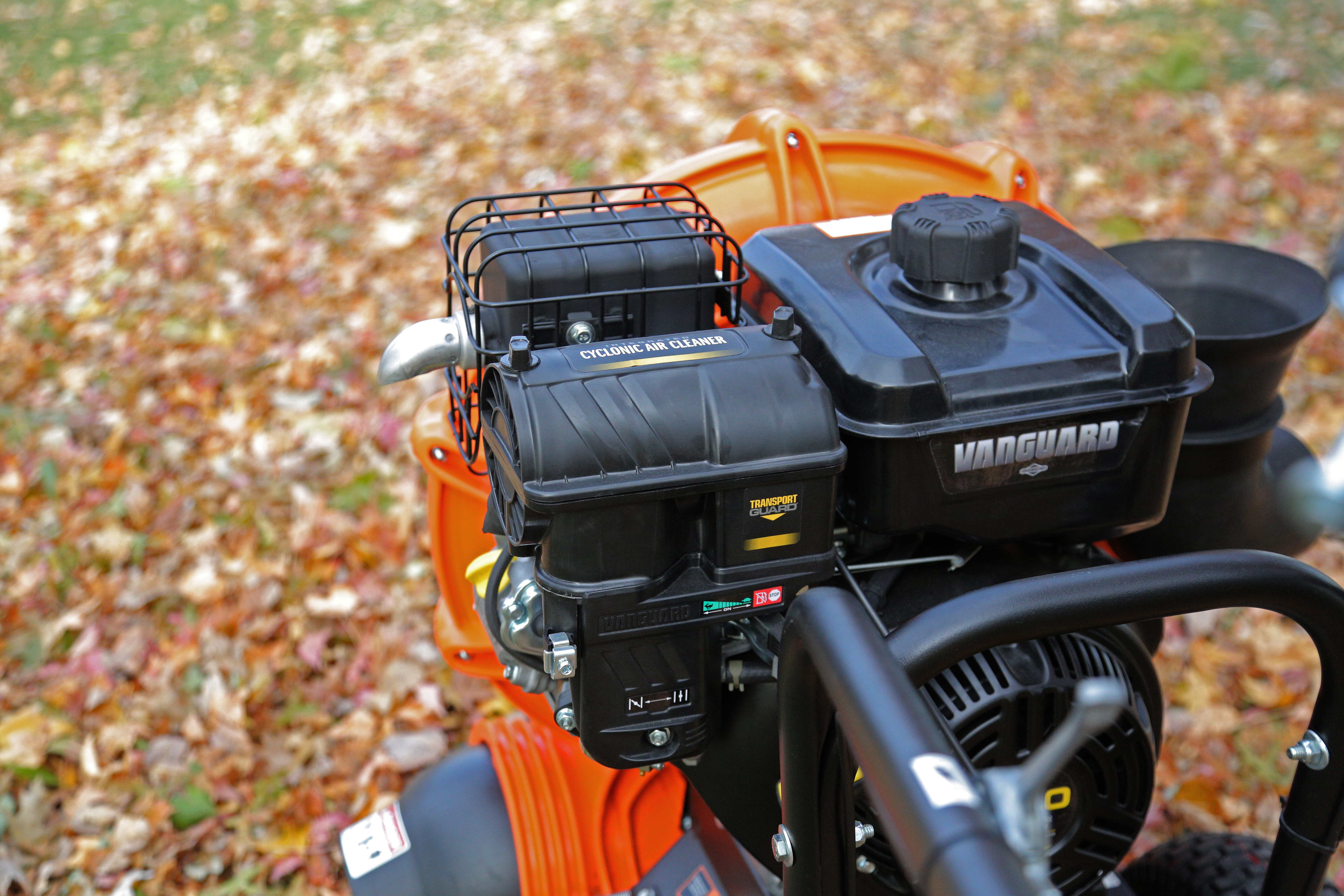 Orange lawn equipment with Vanguard engine amid fallen autumn leaves
