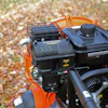 Orange lawn equipment with Vanguard engine amid fallen autumn leaves