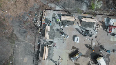 Aerial drone view of construction site with workers and building materials