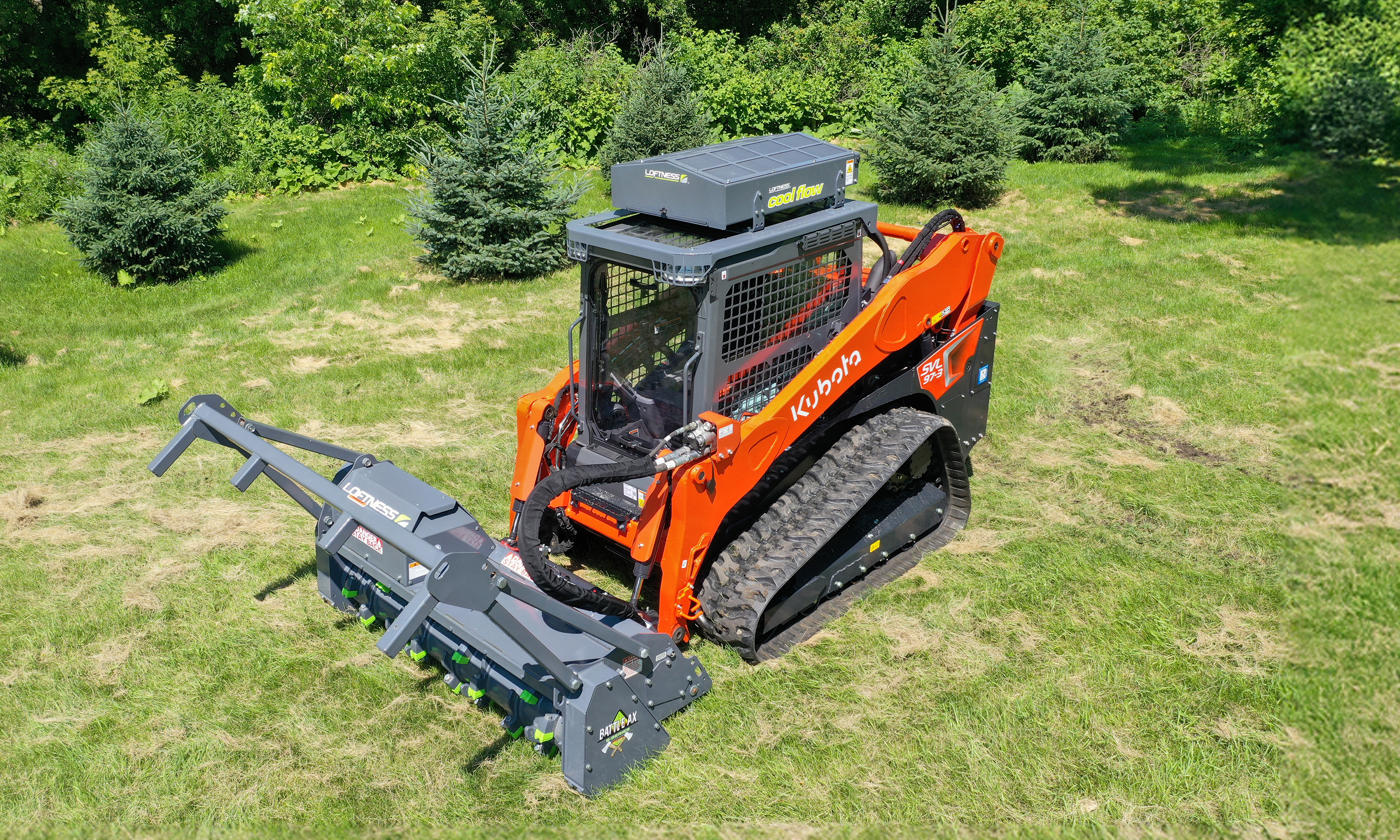 Orange Kubota skid steer loader with forestry mulcher attachment on grassy field