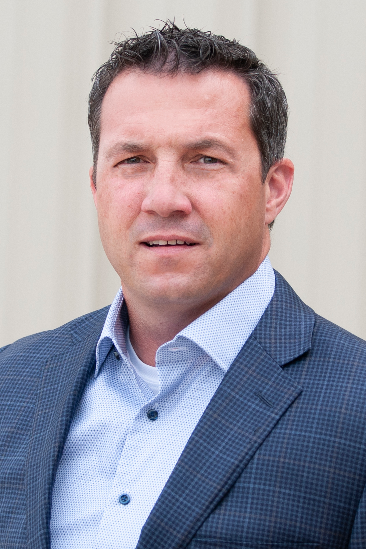 Professional man in blue checkered blazer and light blue shirt Headshot
