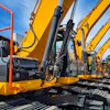 Yellow hydraulic excavators lined up at construction equipment yard