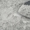 Gray powdery substance spread across surface with mound of dry material