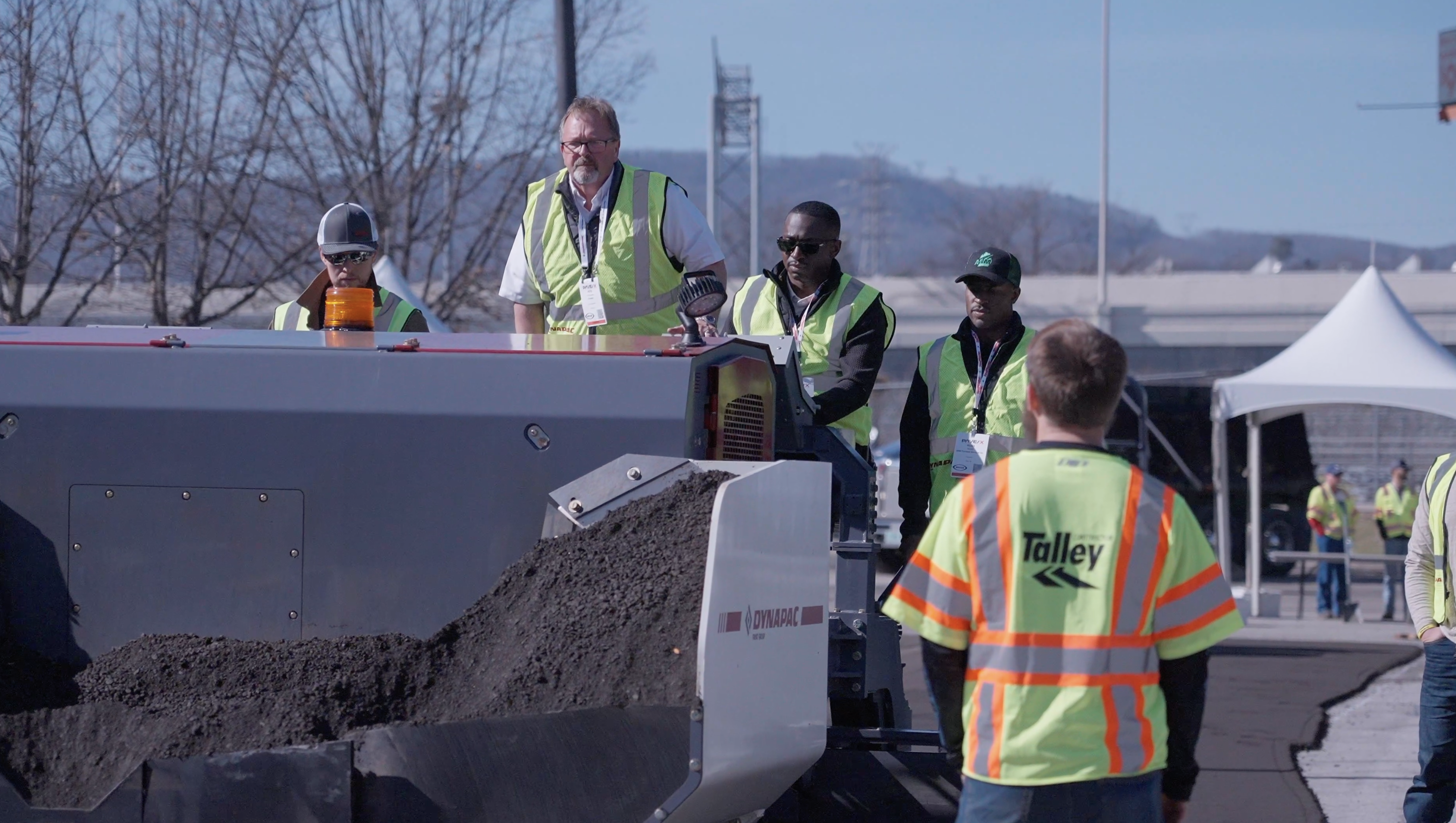 Construction workers operating heavy machinery at an outdoor work site