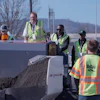 Construction workers operating heavy machinery at an outdoor work site