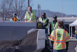 Construction workers operating heavy machinery at an outdoor work site