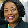 Professional woman smiling, wearing a dark jacket and turquoise jewelry