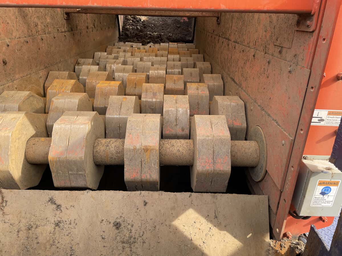 Industrial machinery with rows of large cylindrical rollers in orange metal frame
