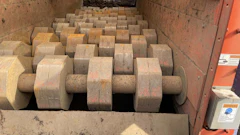 Industrial machinery with rows of large cylindrical rollers in orange metal frame