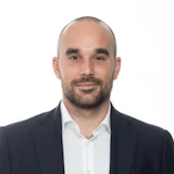 Professional bald man in dark suit and white shirt, neutral background