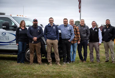 Chappell Tractor team standing beside company truck on grassy field