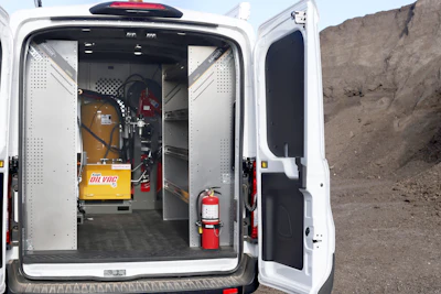 Interior of white service van with equipment, fire extinguisher, and yellow Oilvac container
