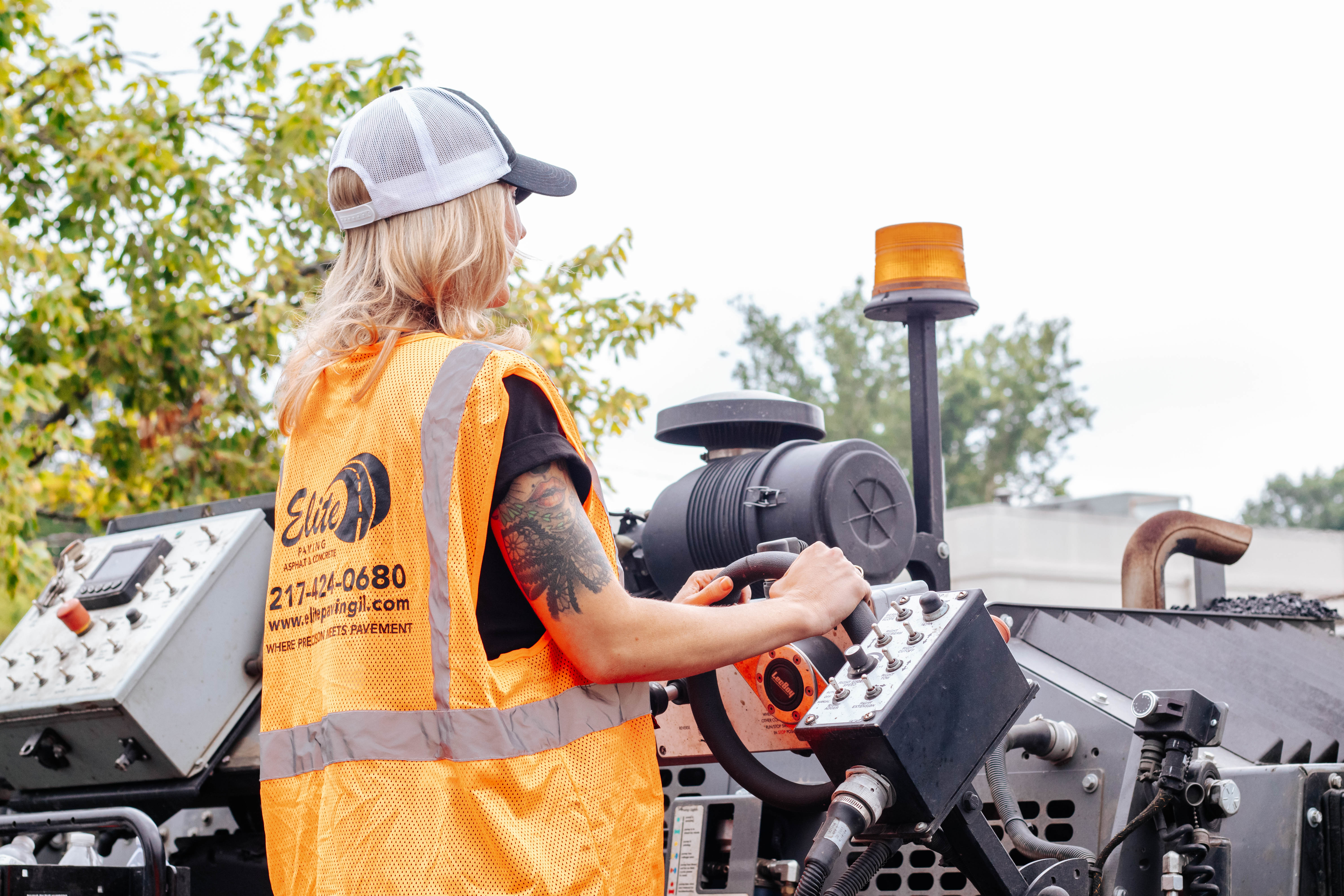 Construction worker operating heavy machinery wearing high-visibility safety vest