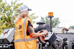 Construction worker operating heavy machinery wearing high-visibility safety vest