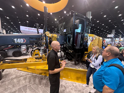 Yellow Caterpillar construction grader at industrial machinery trade show