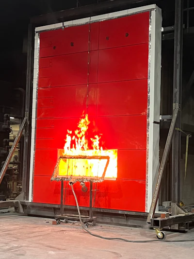 Fire resistance test with flames burning on red industrial testing panel