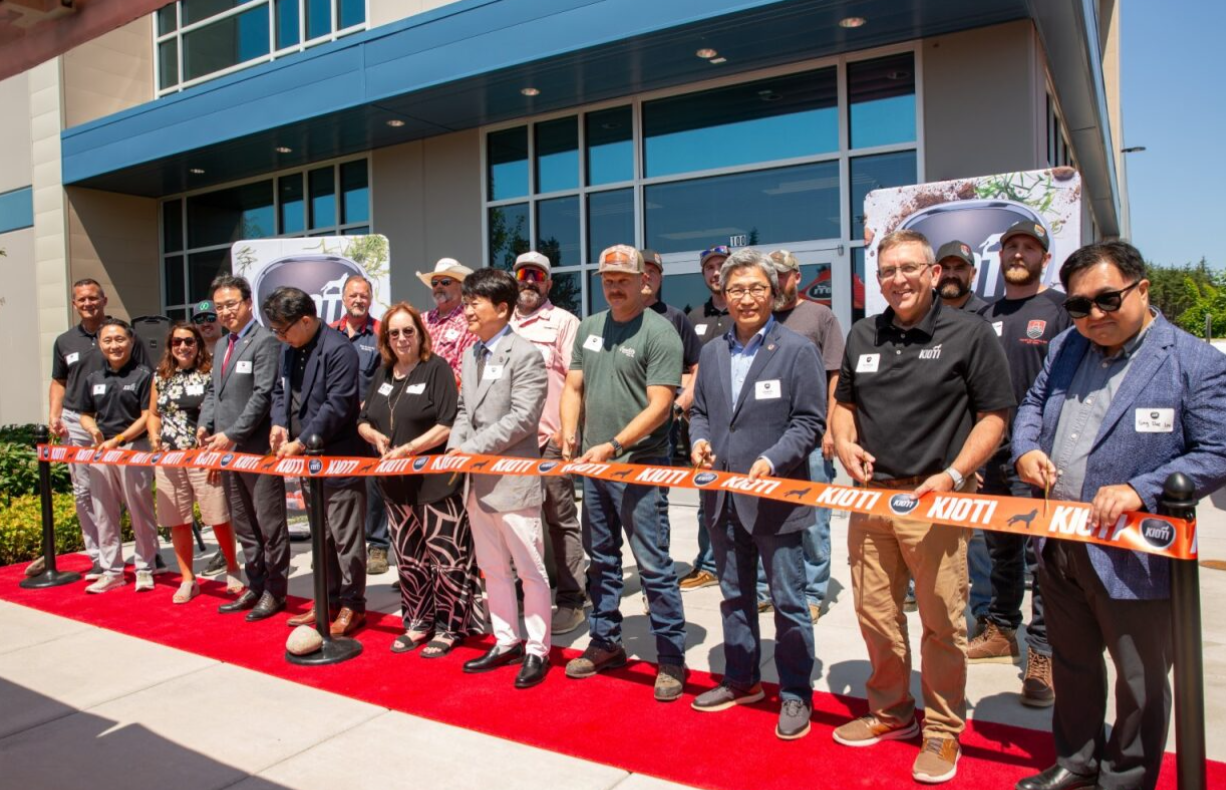 Corporate ribbon-cutting ceremony with diverse group on red carpet outside modern building