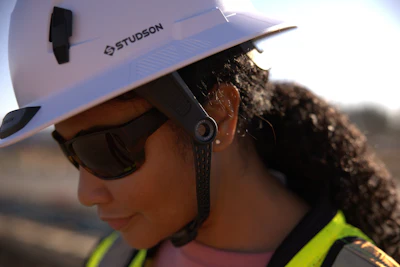 Construction worker wearing white Studson safety helmet and sunglasses