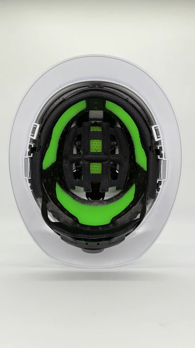 Cross-section of bicycle helmet interior with black frame and bright green padding
