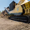 Yellow Vermeer industrial tracked machine processing soil and debris outdoors