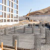 Construction site with steel reinforcement grid and concrete foundation in arid landscape