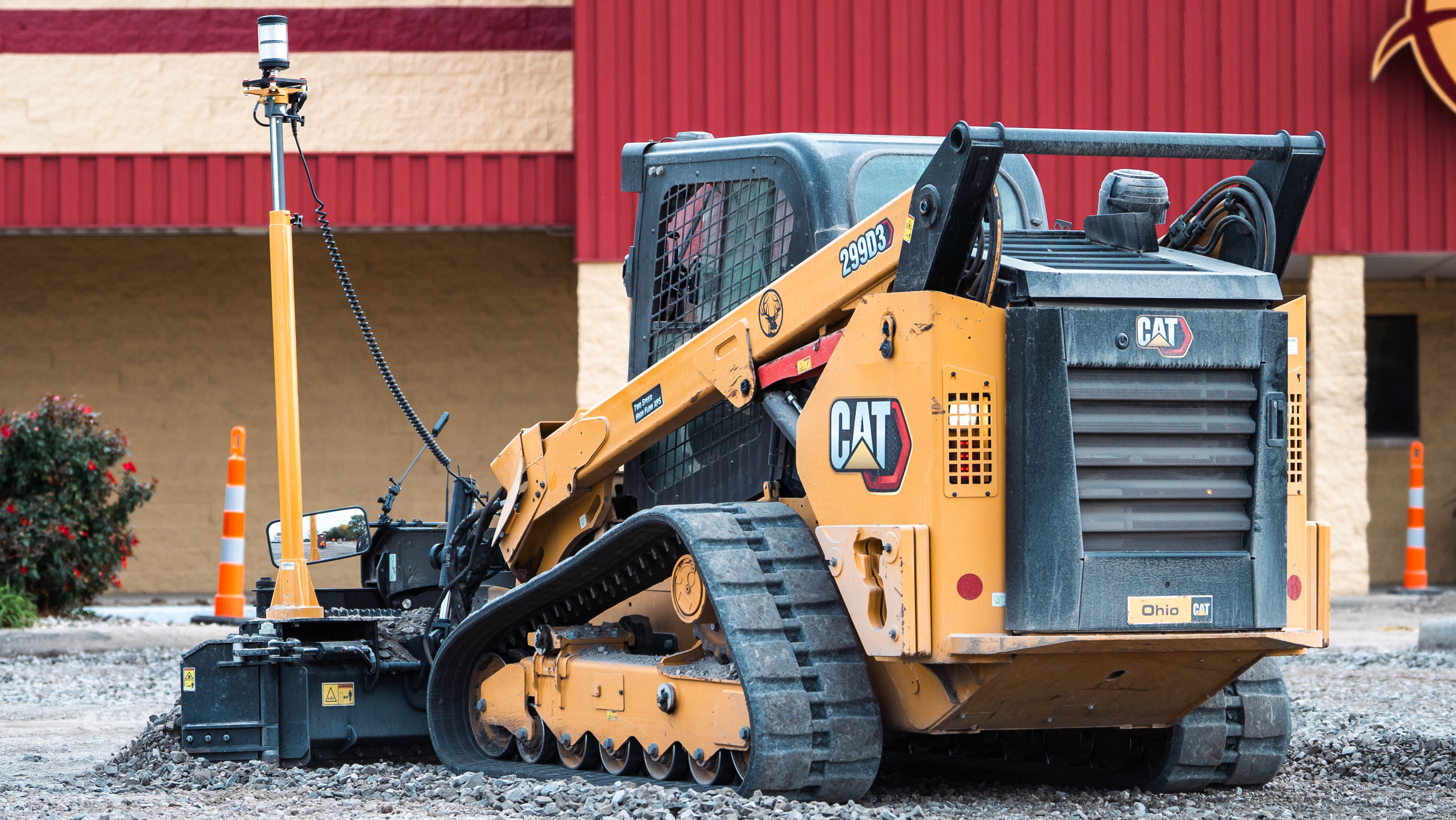 Yellow Caterpillar tracked skid steer loader on gravel construction site