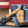 Yellow Caterpillar tracked skid steer loader on gravel construction site