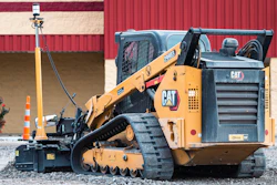 Yellow Caterpillar tracked skid steer loader on gravel construction site