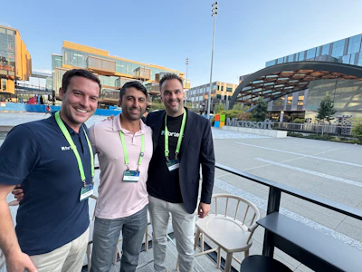Three professionals standing together at Microsoft headquarters outdoor plaza