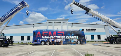 Manufacturing Express bus parked between two cranes at industrial facility