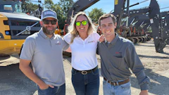 Three professionals standing near Volvo excavators at construction equipment site
